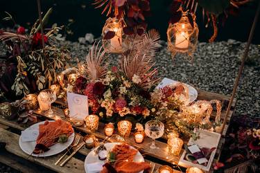 Hochzeitsdeko Trends 2021: Outdoor-Tiny Wedding mit zum Tisch umfunktionierter Palette geschmückt im Boho-Stil