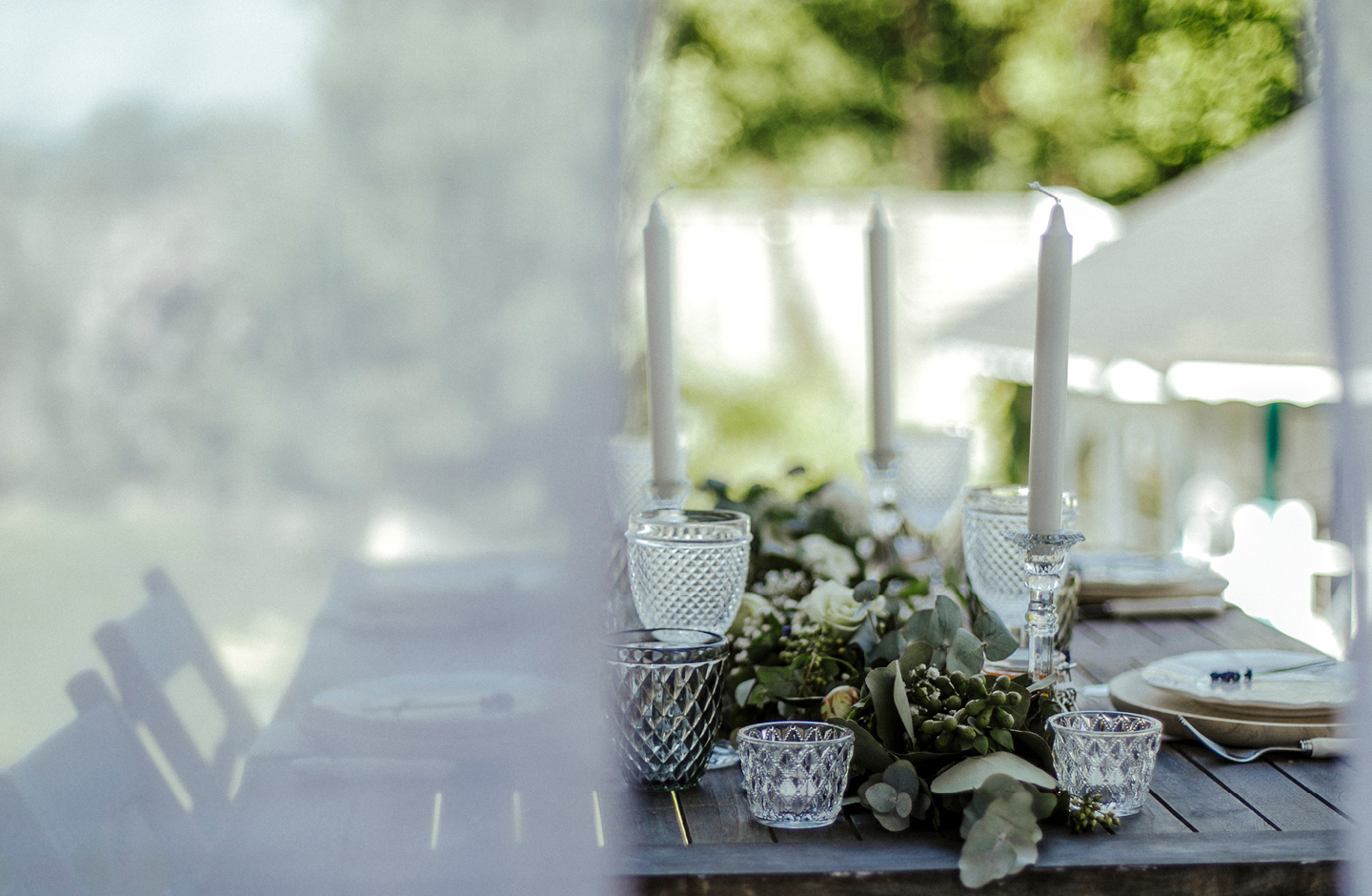 Hochzeitstafel ist nachhaltig dekoriert mit Blättern aus dem Garten und wiederverwendbaren Gläsern.