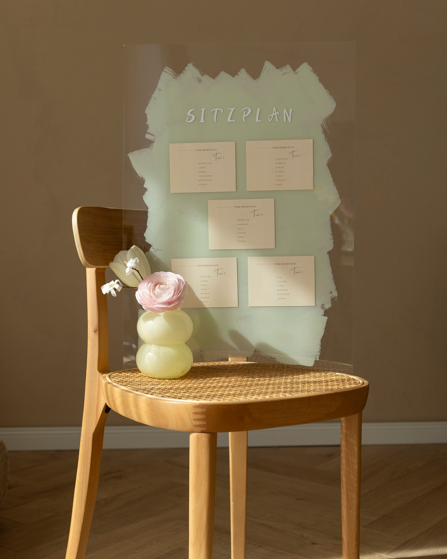 Kreativer Sitzplan zur Hochzeit mit Flaschenetiketten auf einer bemalten Acrylplatte