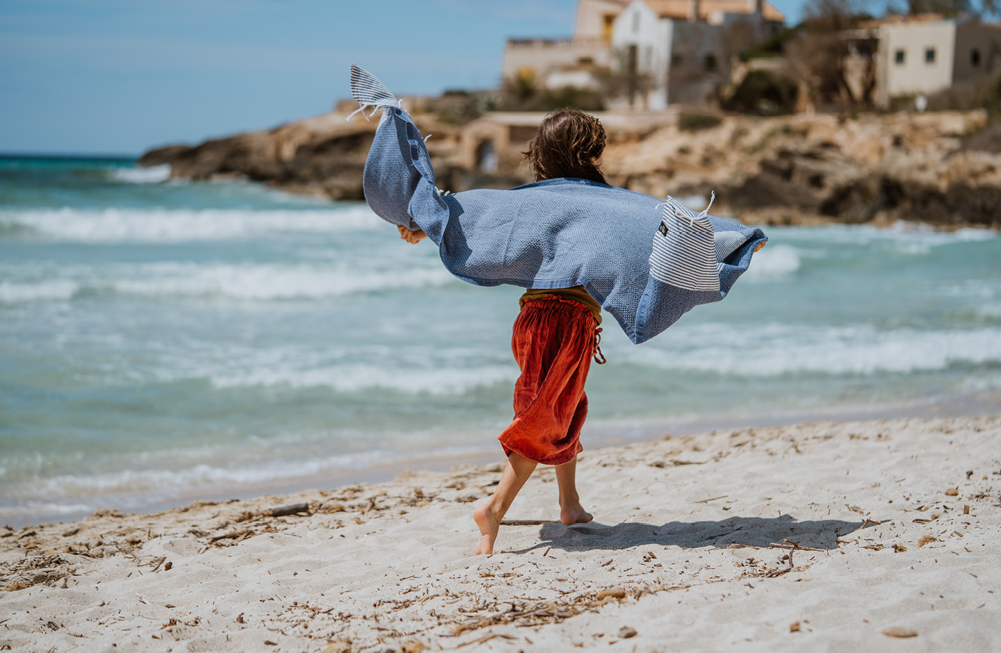 Etwa 8-jähriges Mädchen geht am Strand spazieren