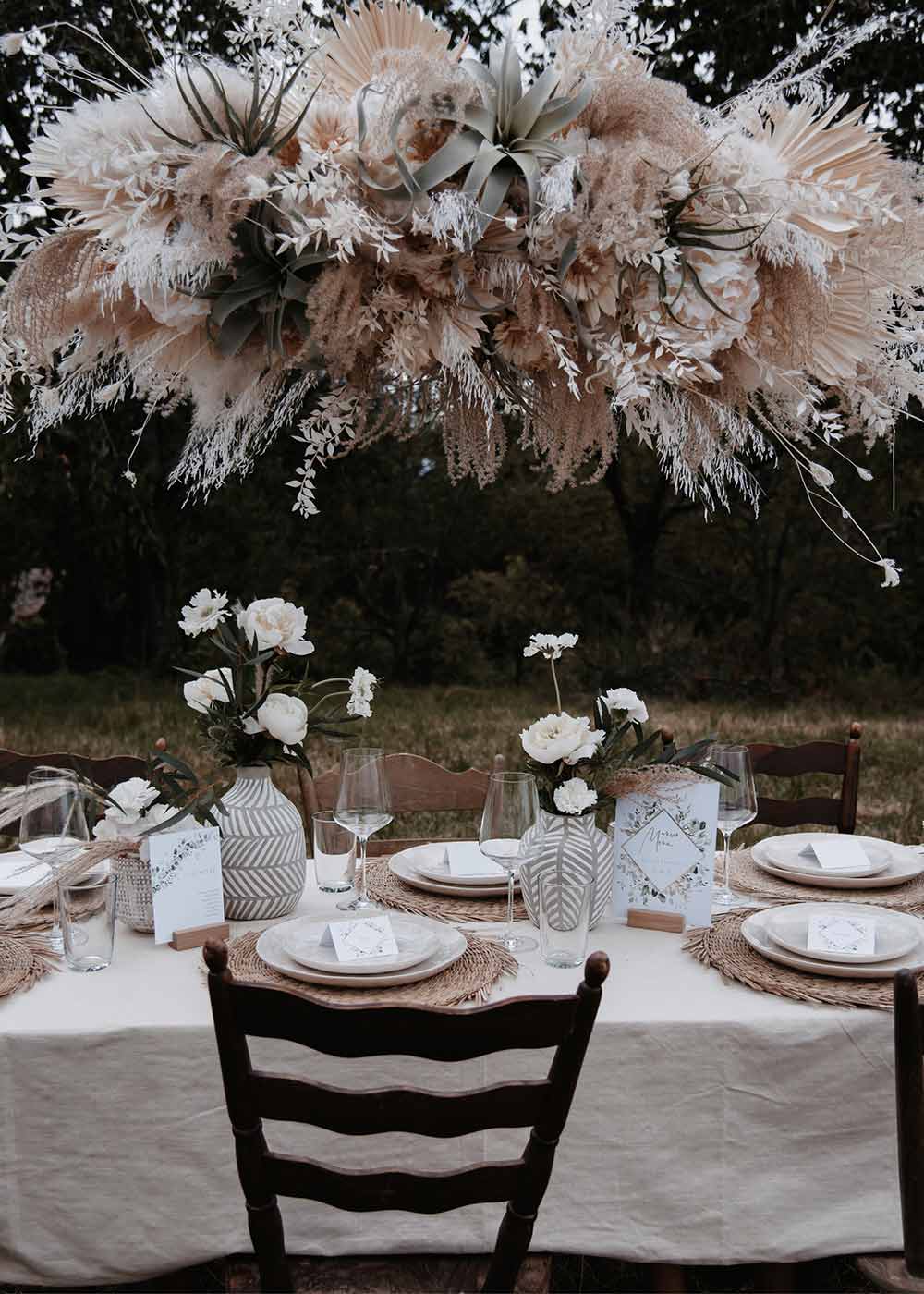 Das Highlight am Hochzeitstisch ist die auffällige Pflanzendeko über den Tischen. Zusammen mit den Blumen auf den Tischen und der liebevoll ausgewählten Papeterie wirken sie sehr harmonisch.