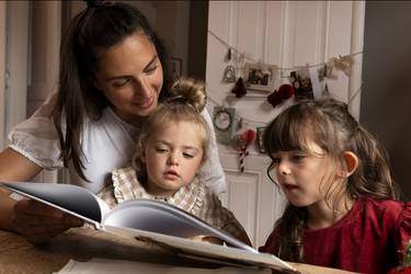 Mutter liest ihren kleinen Töchtern in der Adventszeit ene Geschichte vor