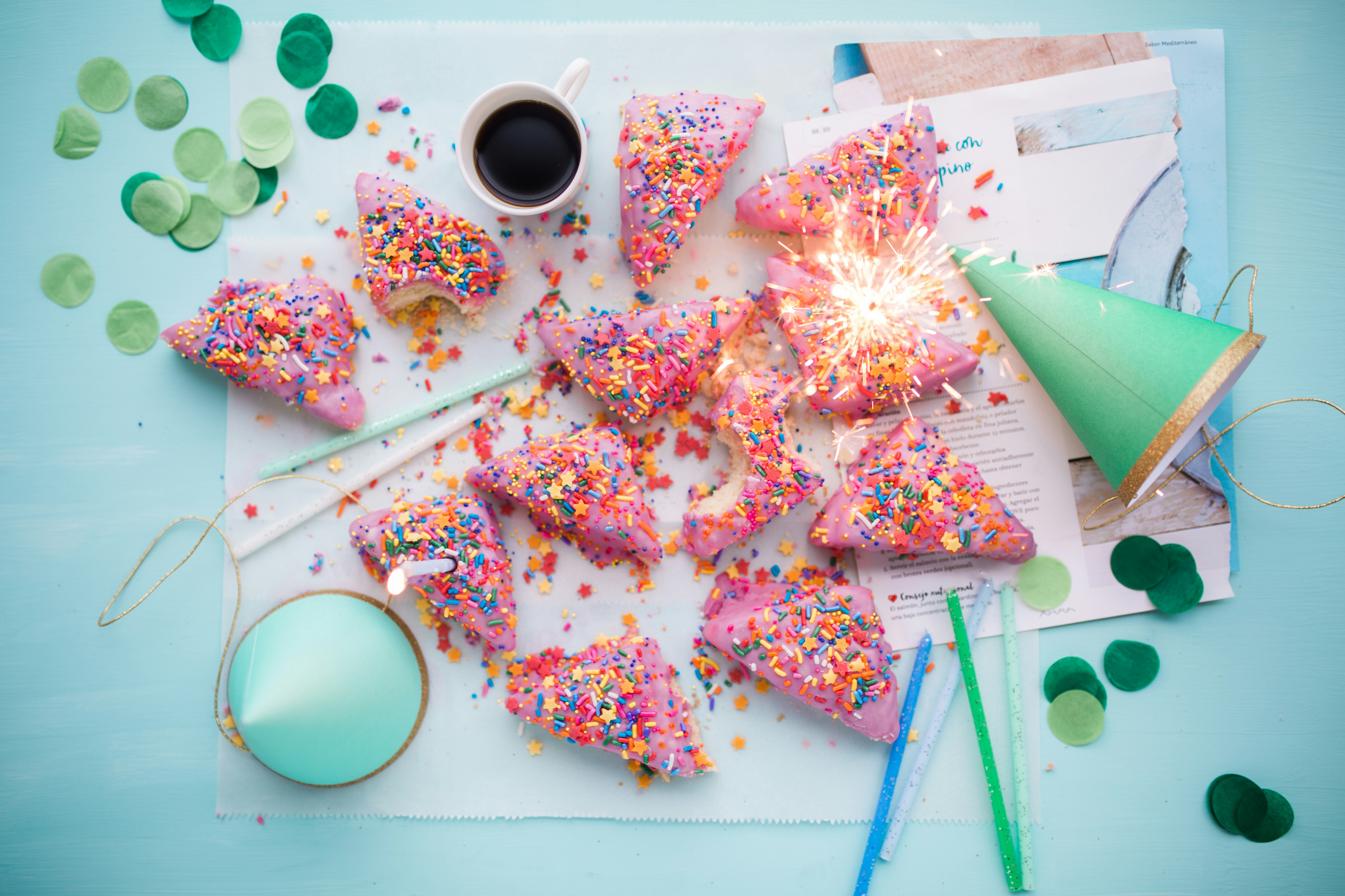 Geburtstagstisch mit Wunderkerze, Kuchen und Partyhut