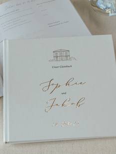 Hochzeitsgästebuch und goldfarbener Kugelschreiber auf einem Tisch