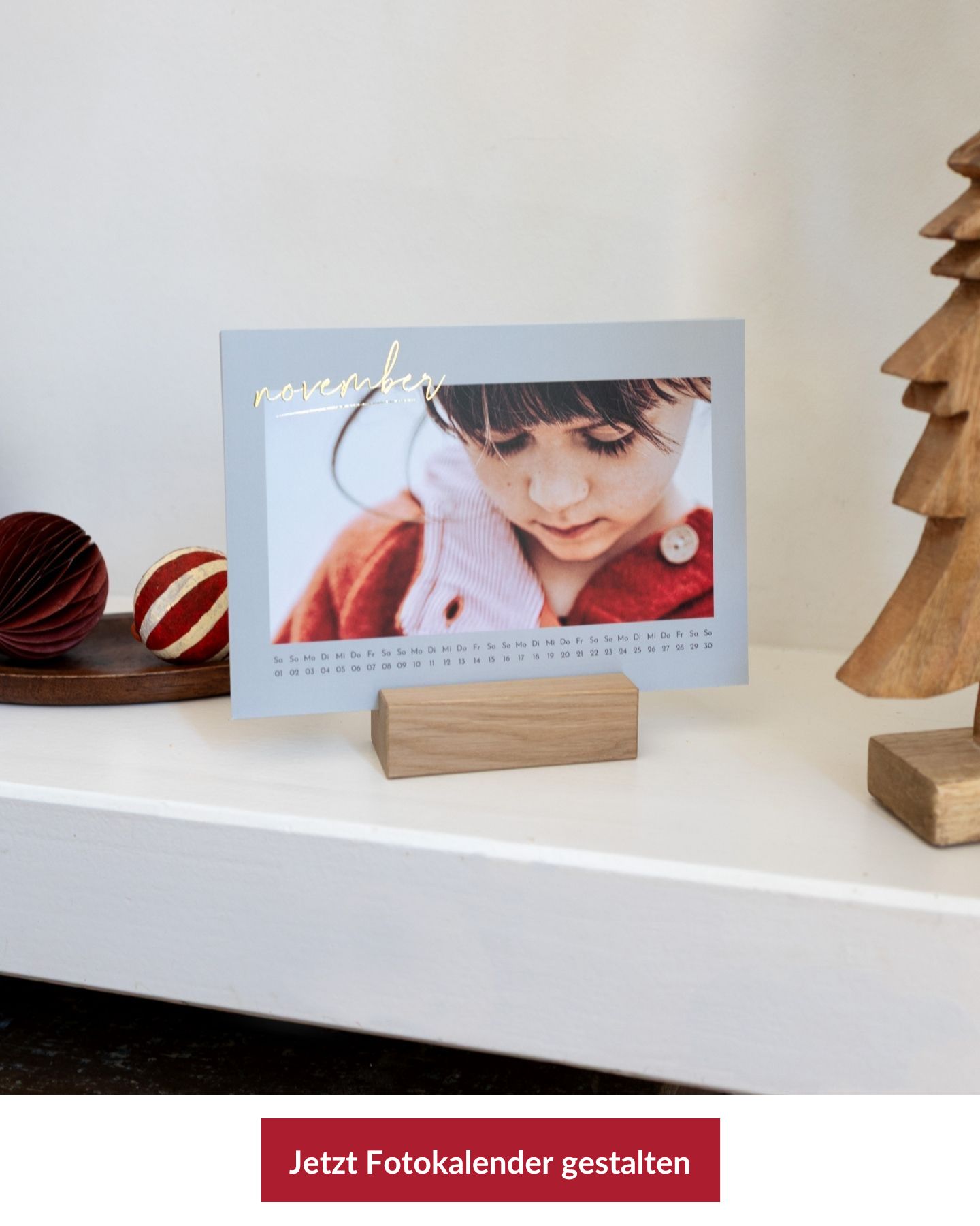 Fotokalender auf weißem Regal mit Weihnachtsdeko