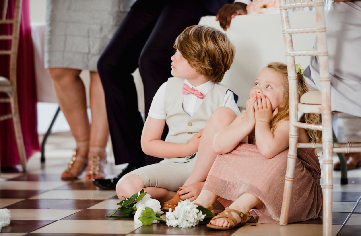 Zwei Kinder sitzen auf dem Boden bei einer Hochzeit