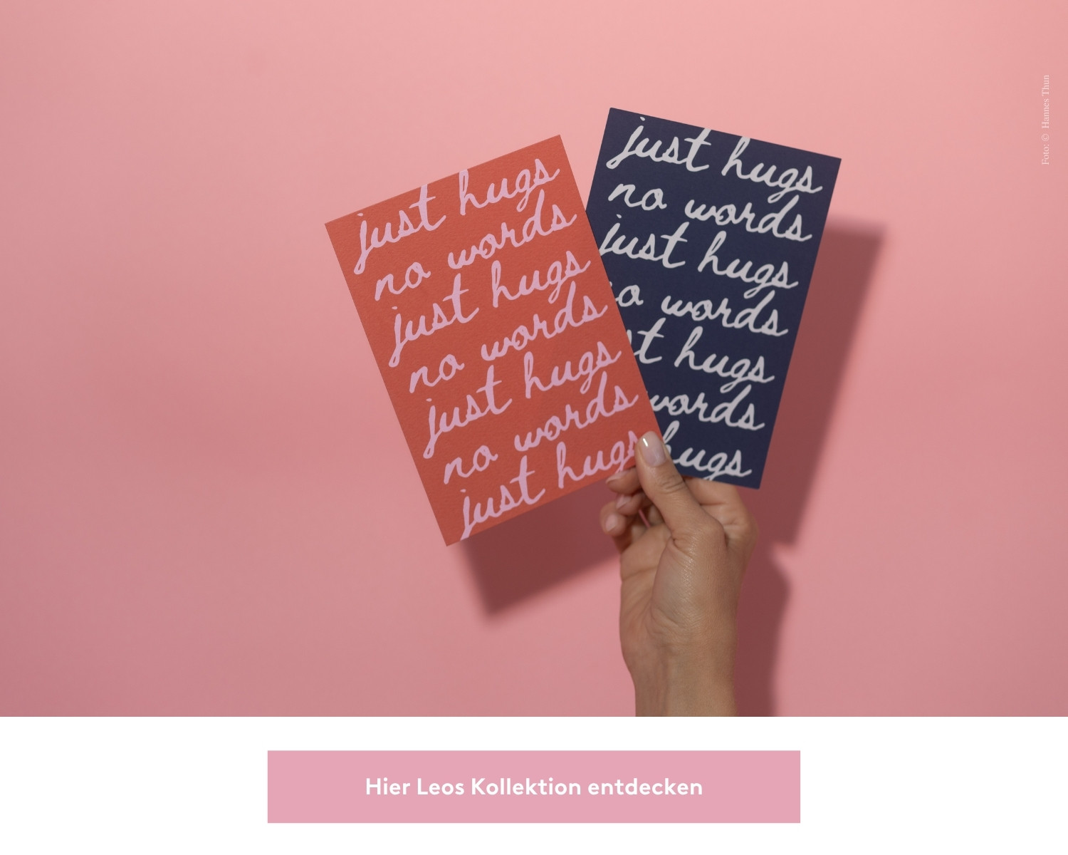 Leo hält zwei Trauerkarten in der Hand. Auf beiden steht in schnörkeliger Schrift "just hugs no words". Die linke Karte ist rot und die rechte Karte ist blau