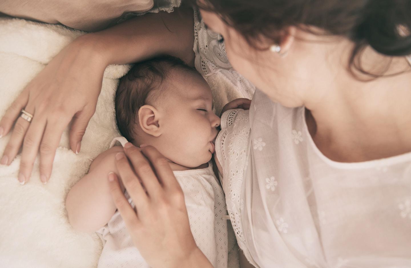 Junge Mutter stillt Baby 1 Monat alt im Bett