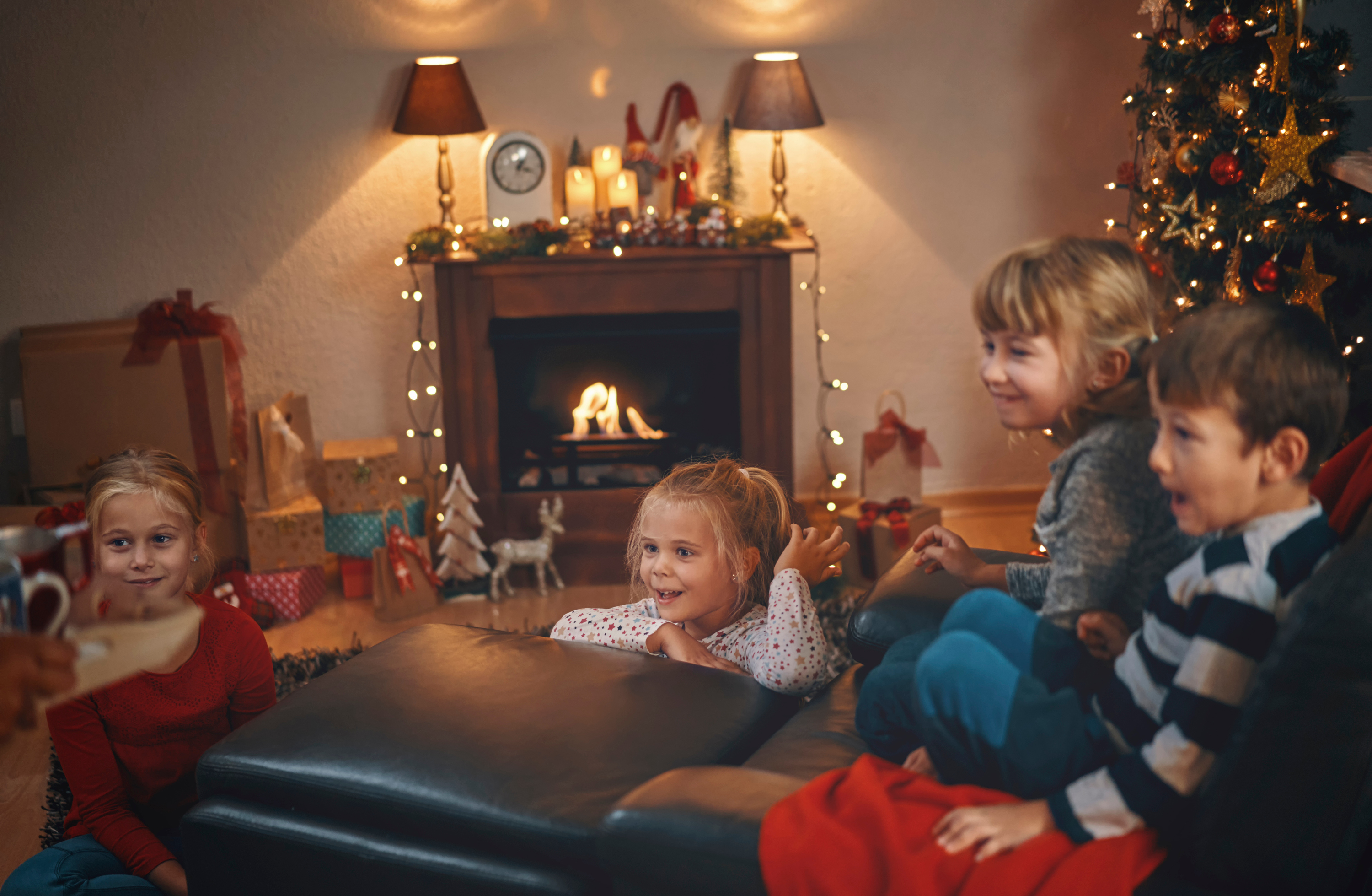  Kinder genießen die Adventszeit im geschmückten Wohnzimmer