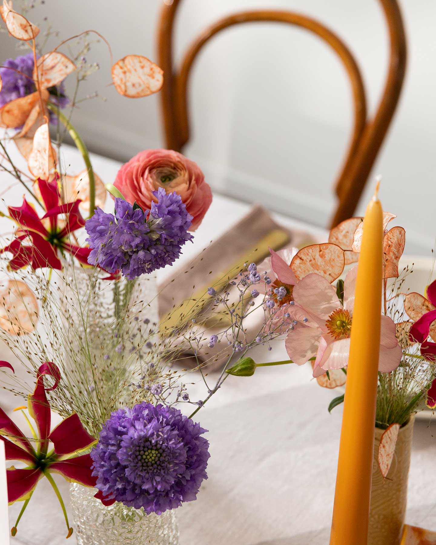 Tischdekoration zur Taufe mit bunten Blumen.
