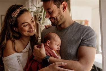 Glückliche Eltern, der Vater hält die neugeborene Tochter auf dem Arm