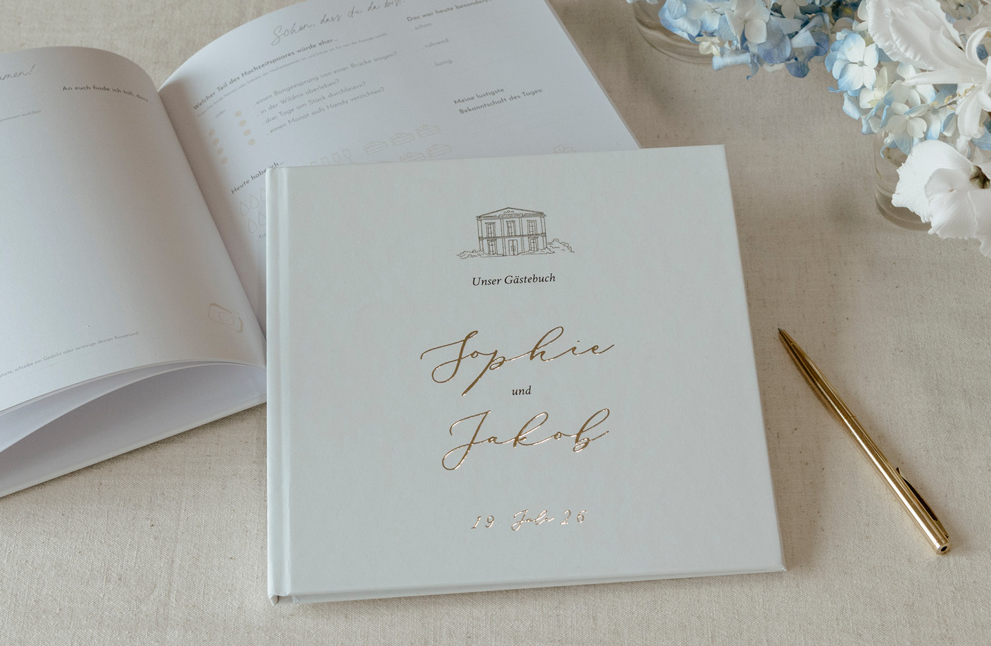 Hochzeitsgästebuch auf einem Tisch mit goldenem Kugelschreiber