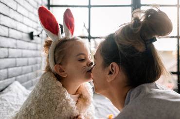 Ostersprüche: Tochter küsst Mutter an Ostern auf die Nase